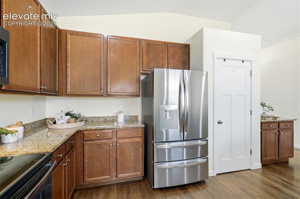 Image 13 of 45: Kitchen featuring wood-finish flooring, granite countertops, and stainless 