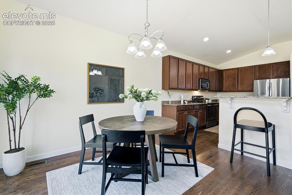 Image 16 of 45: Hardwood-finish flooring, recessed lighting, chandelier lighting, and a bre