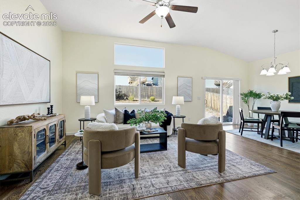 Image 18 of 45: Vaulted ceiling with a ceiling fan, wood-finish flooring, multiple windows,
