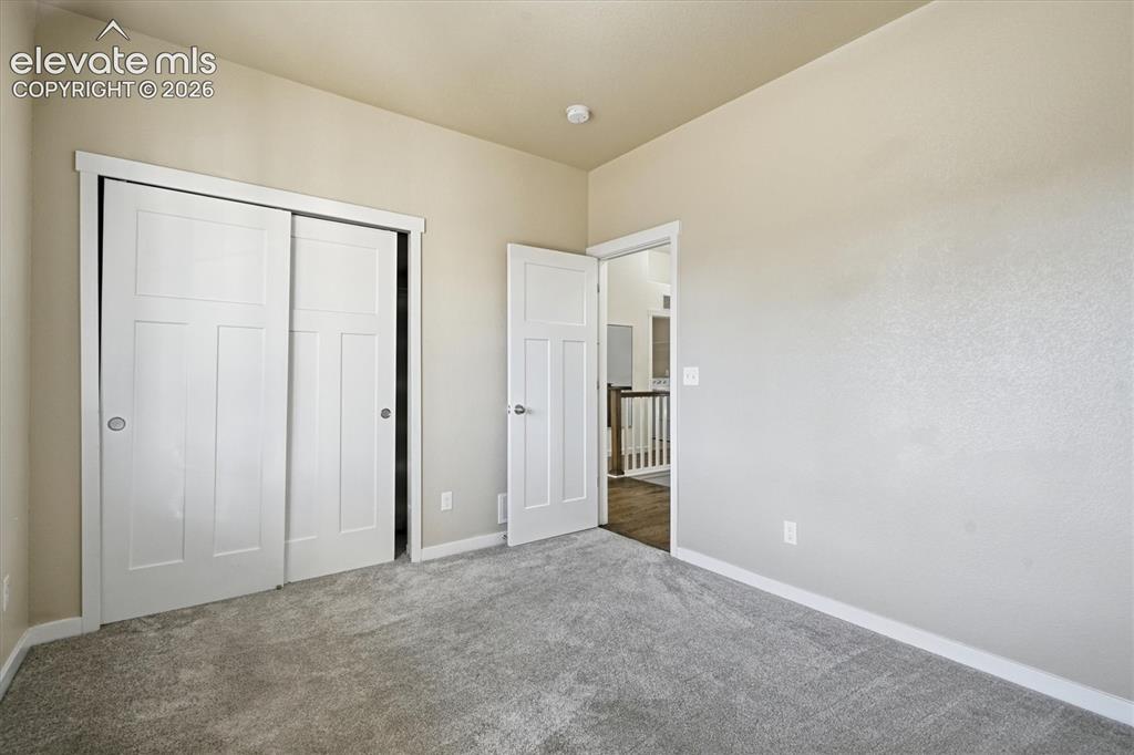 Image 6 of 45: Neutral wall tones with crisp white trim, plush gray carpeting, and paneled