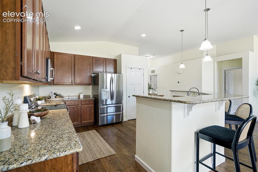 Image 9 of 45: Kitchen featuring granite countertops, stainless steel appliances, wood-fin