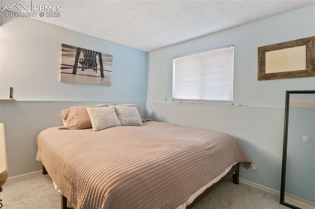 Image 16 of 28: Carpeted bedroom featuring a textured ceiling