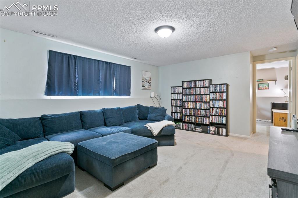Image 20 of 28: Living area with carpet floors and a textured ceiling