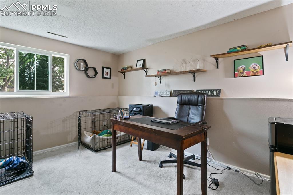 Image 21 of 28: Office space with light carpet and a textured ceiling
