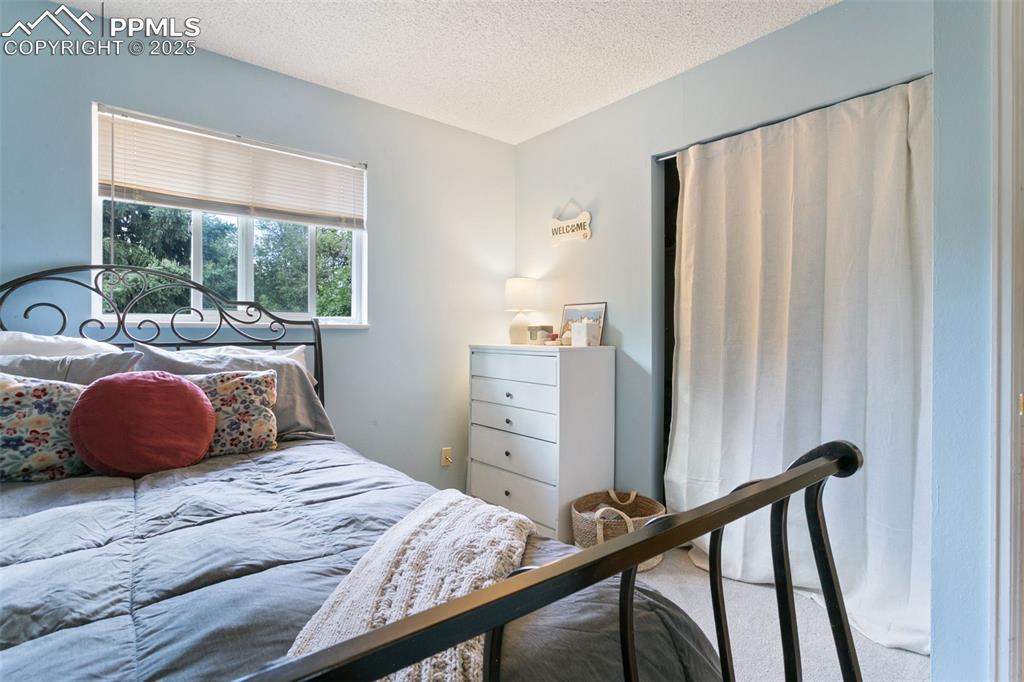 Image 22 of 28: Bedroom with carpet and a textured ceiling
