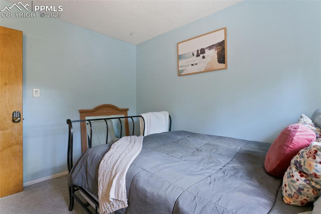 Image 23 of 28: Bedroom with carpet and a textured ceiling