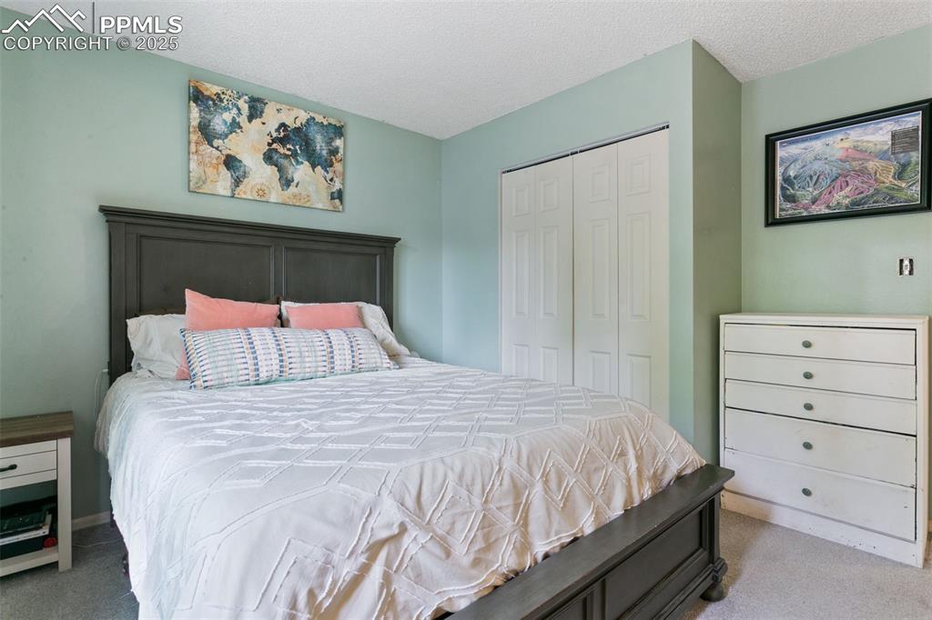 Image 27 of 28: Bedroom featuring carpet flooring, a textured ceiling, and a closet