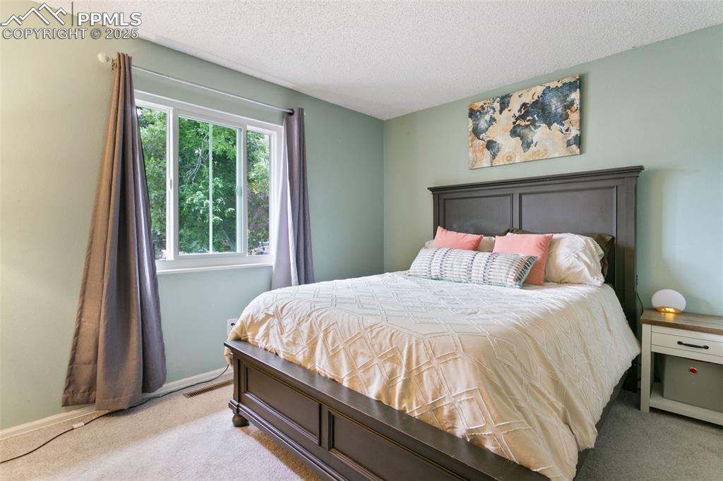 Image 28 of 28: Bedroom with carpet floors and a textured ceiling