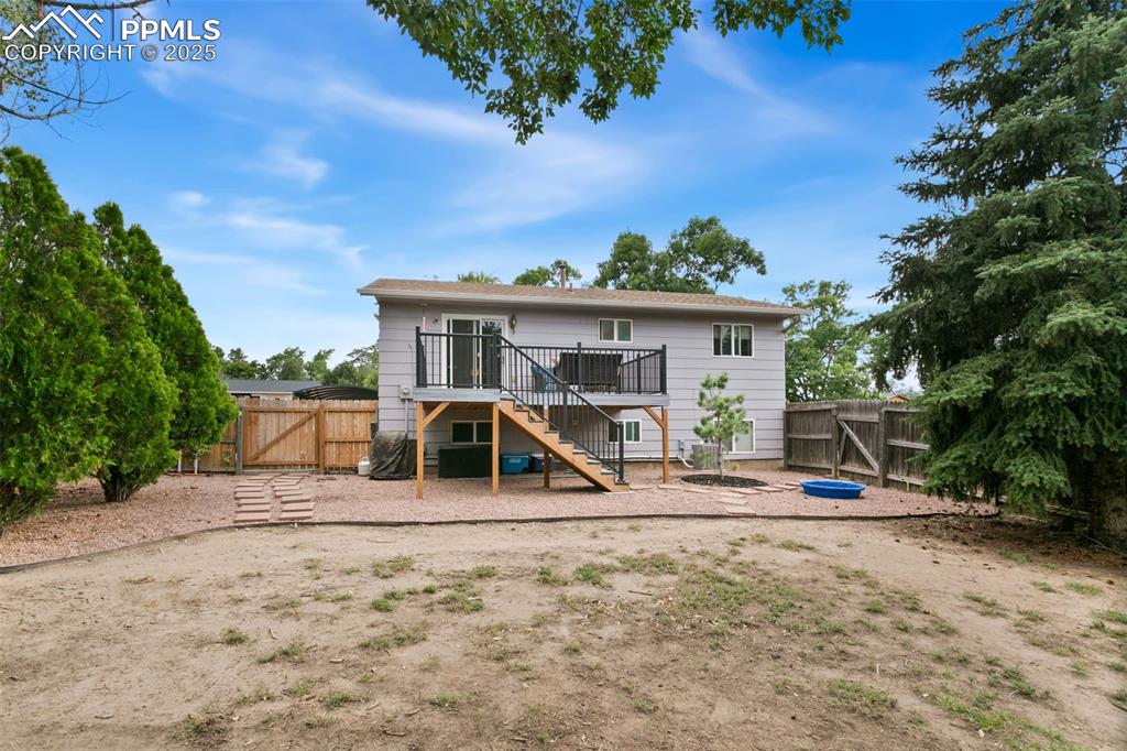 Image 3 of 28: Back of house featuring a gate, a patio, stairs, and a fenced backyard