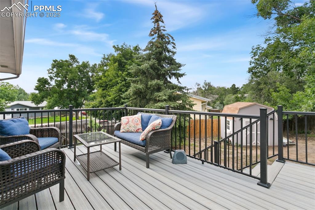 Image 5 of 28: Wooden deck with outdoor lounge area and an outbuilding
