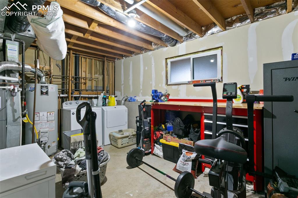 Image 6 of 28: Unfinished below grade area featuring water heater, washing machine and dry