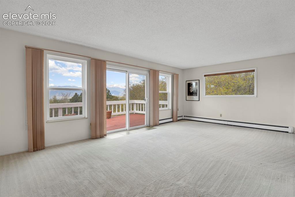 Image 12 of 37: Large living room with walk out to panoramic mountain views