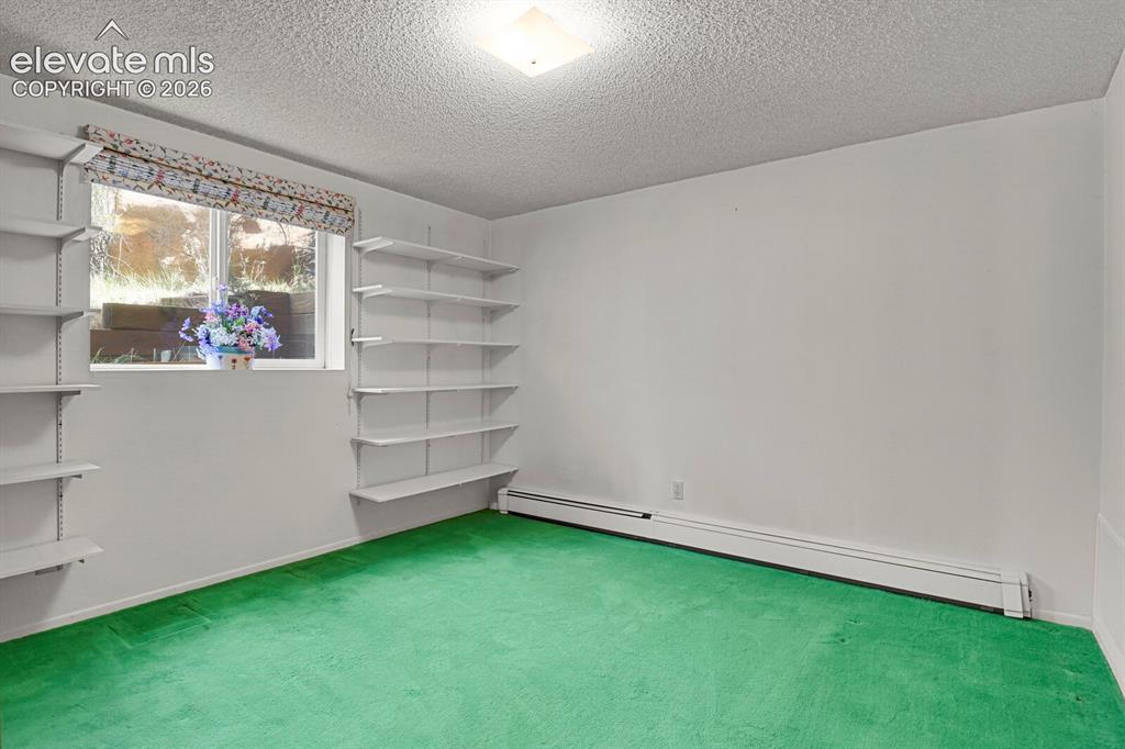 Image 21 of 37: Main level bedroom with walk in closet and shelves
