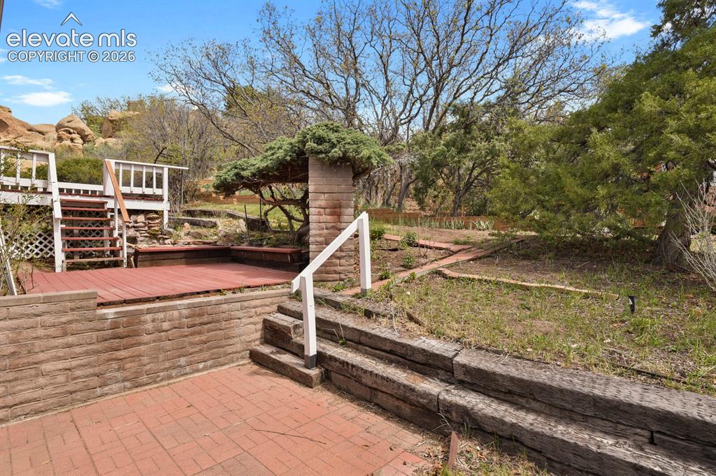 Image 25 of 37: Back with water feature, lily pond with goldfish & 2 patios & 1 deck