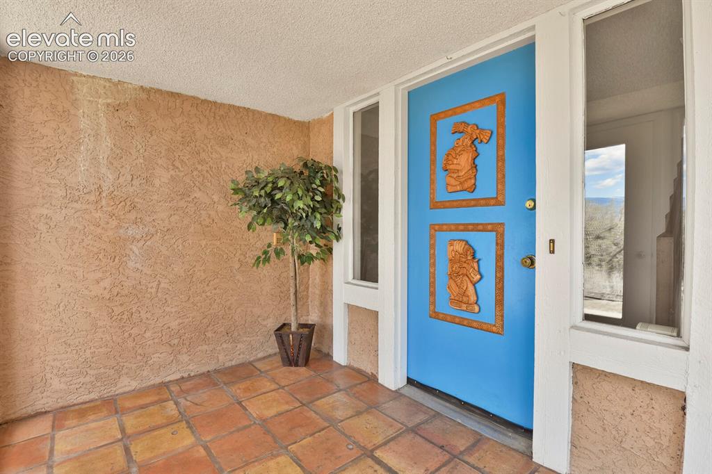 Image 4 of 37: Enclosed foyer with terra cotta tile