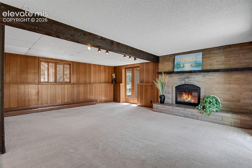 Image 5 of 37: with wood burning fireplace hearth, wet bar & walk out to the sunroom