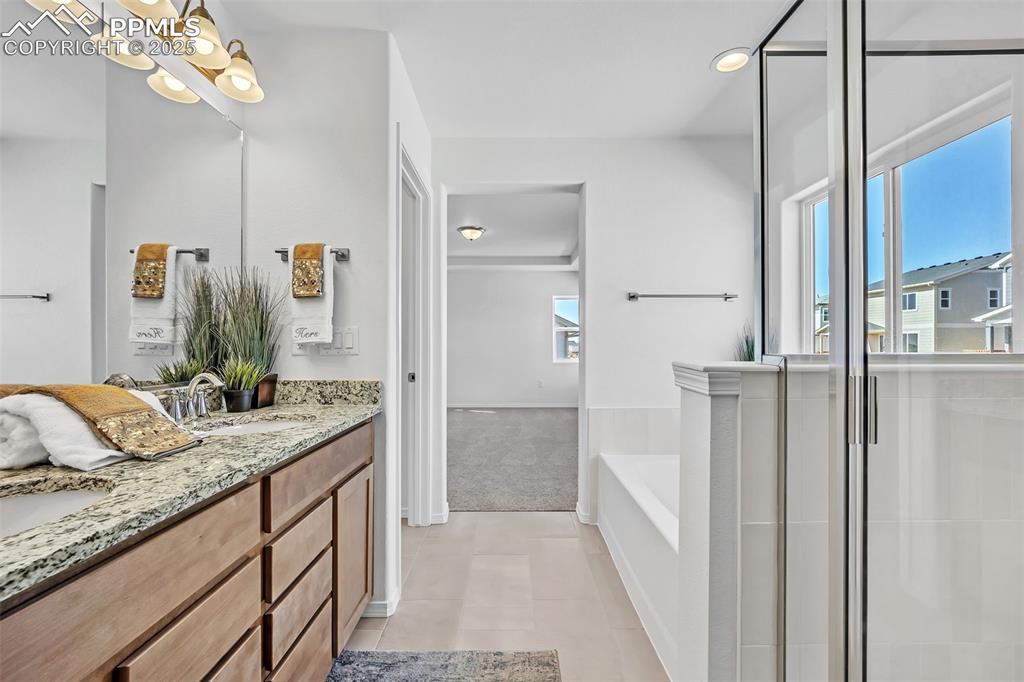 Image 26 of 33: Full bathroom featuring tile patterned floors, vanity, a bath, baseboards,