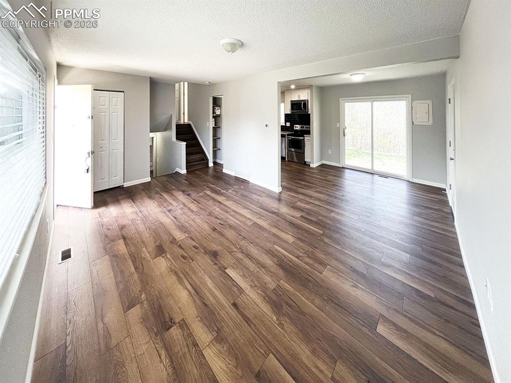 Image 2 of 23: Living room, looking into the dining area and kitchen