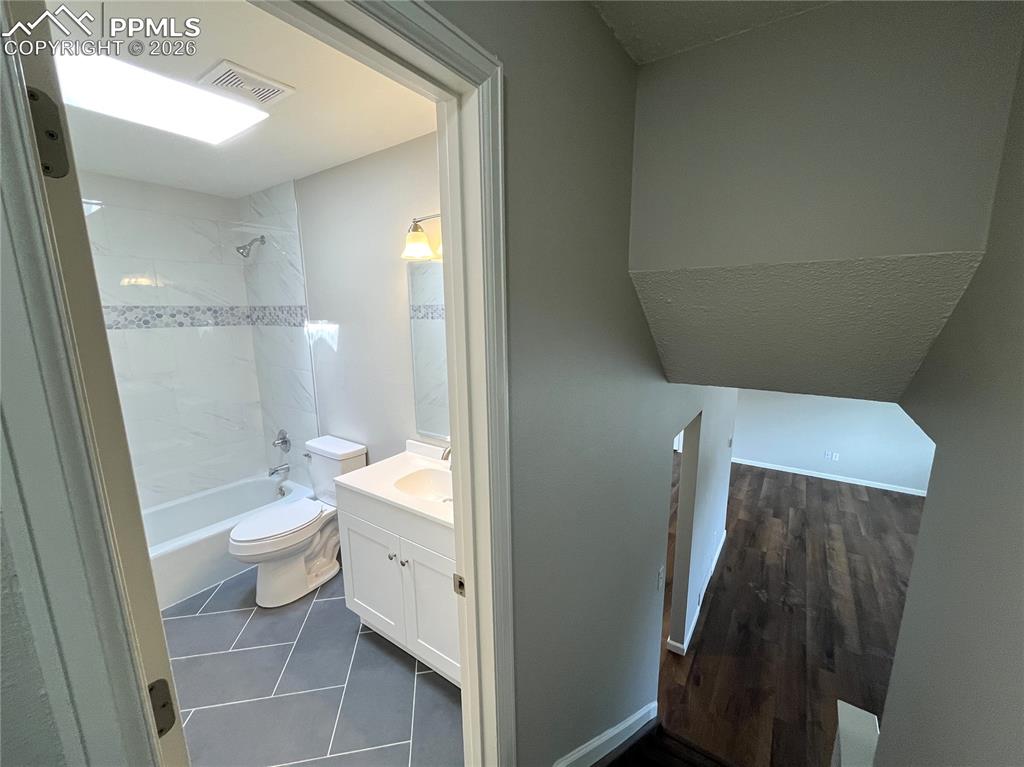 Image 20 of 23: Upper level hallway full bathroom, looking down to the main level