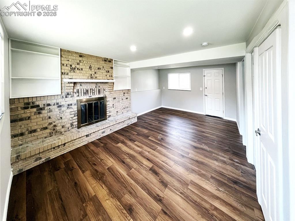 Image 8 of 23: Lower level family room, with wood burning fireplace and walk out to backya