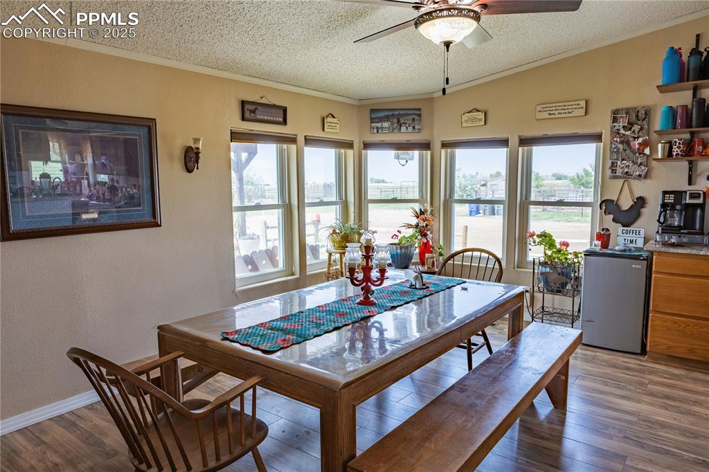 Image 30 of 50: Dining space featuring a textured ceiling, a ceiling fan, crown molding, wo