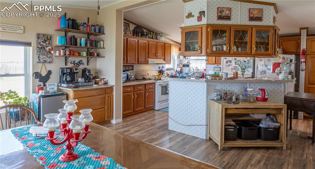 Image 32 of 50: Kitchen featuring white range with electric stovetop, light wood-style floo