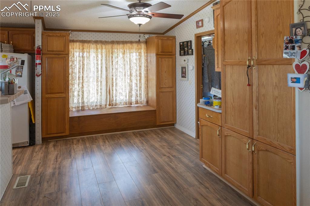Image 50 of 50: Kitchen featuring wallpapered walls, crown molding, a ceiling fan, freestan