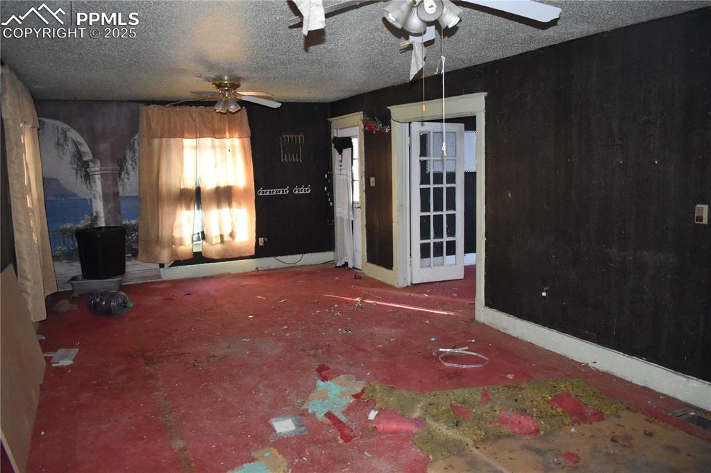 Image 23 of 23: Unfurnished living room with a textured ceiling and a ceiling fan