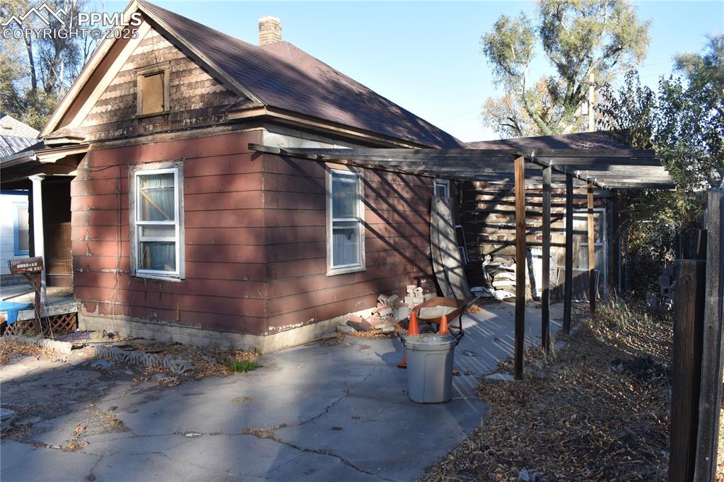 Image 3 of 23: View of property exterior with a shingled roof and a chimney