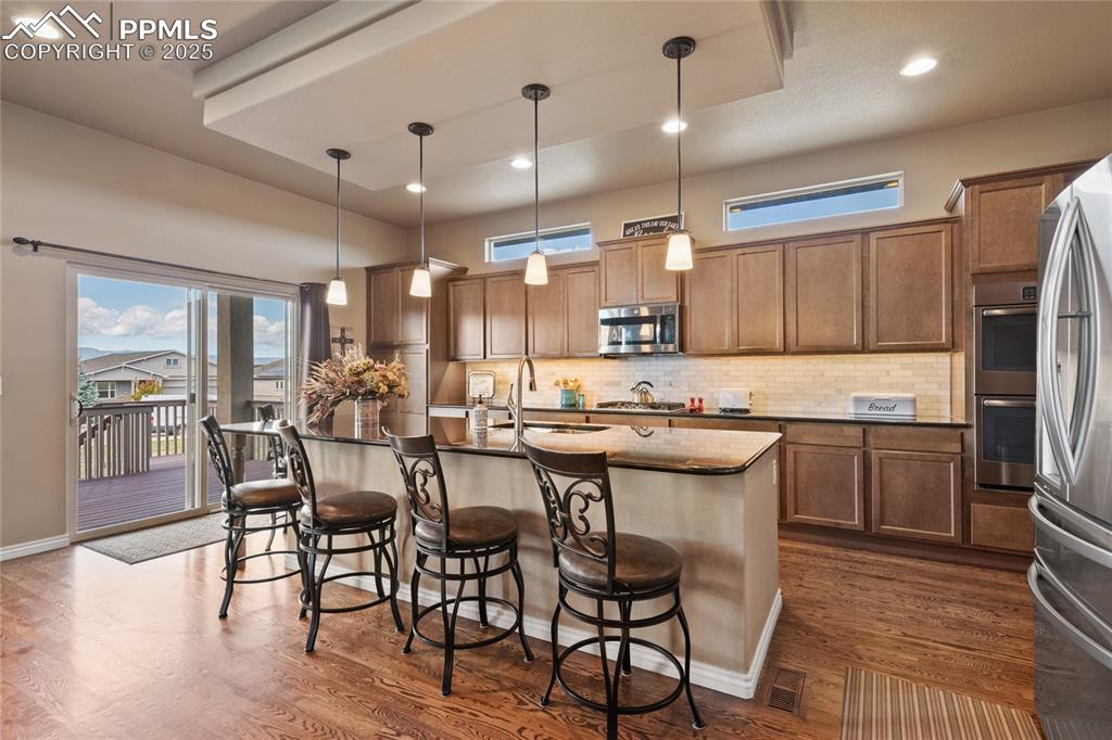 Image 18 of 49: Large island for extra seating with walkout to the covered deck.