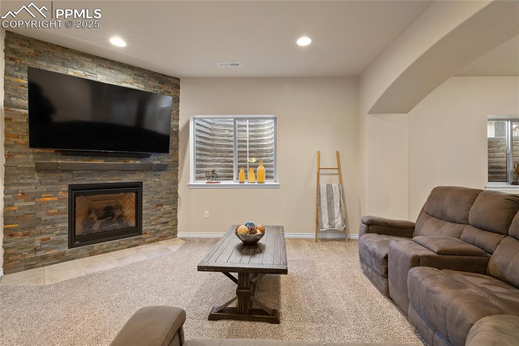 Image 37 of 49: Lower level family room with gas fireplace.