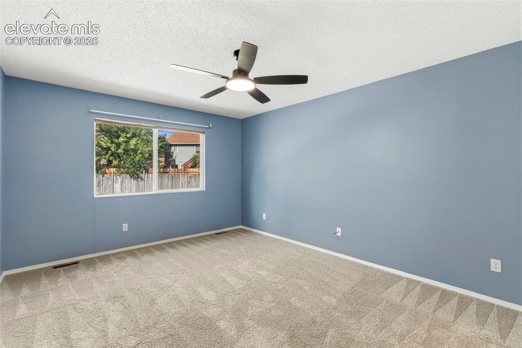 Image 21 of 50: Main level primary bedroom w/ updated ceiling fan!