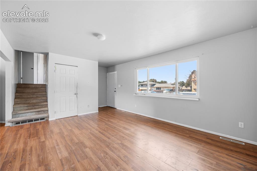 Image 2 of 31: Wood laminate flooring and front yard views from the spacious Living Room