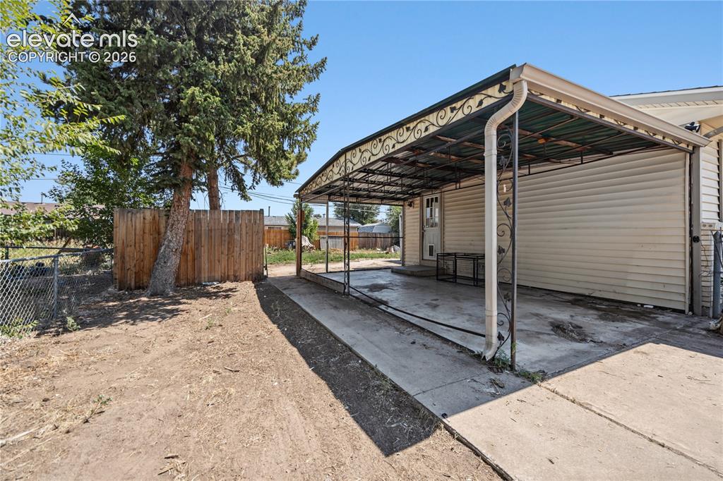 Image 24 of 31: Covered backyard patio for outdoor dining and relaxation.