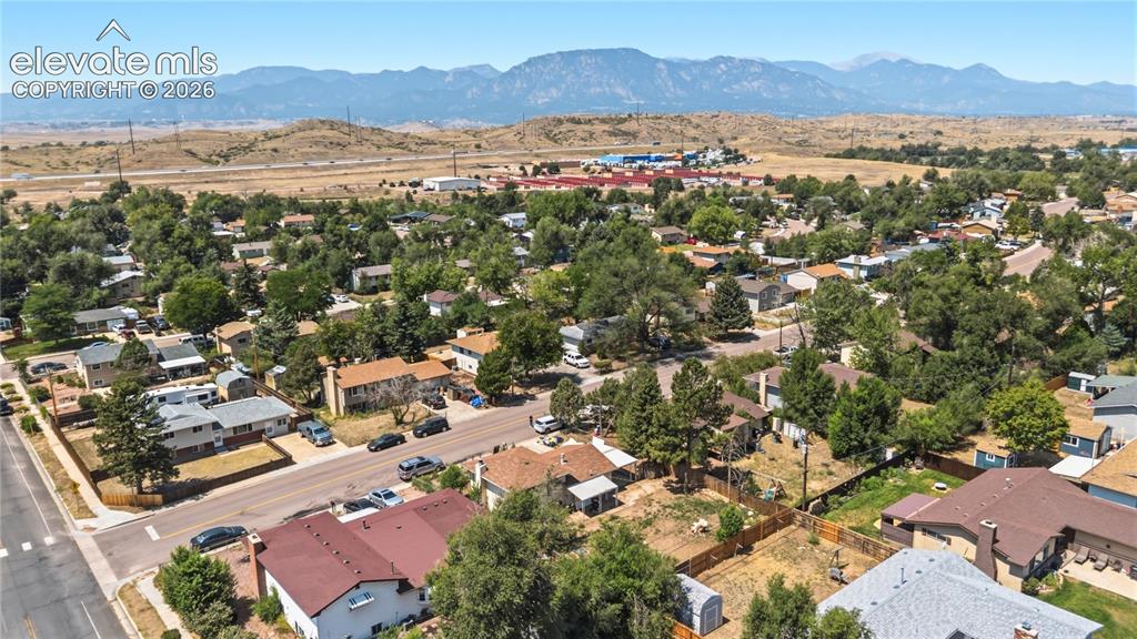 Image 27 of 31: Aerial rear view of backyard and neighborhood with mountain views.