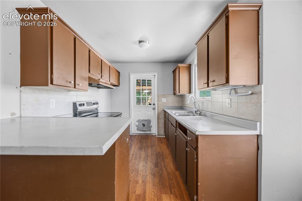 Image 6 of 31: The walk-out Kitchen features wood cabinets, laminate countertops, a breakf
