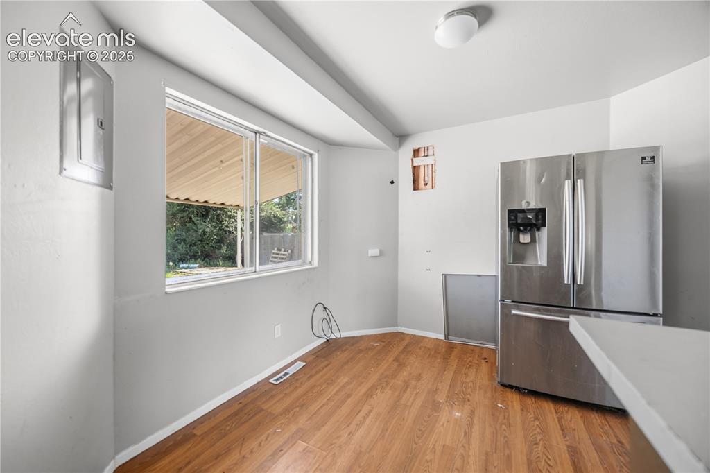 Image 8 of 31: Dining Area with wood laminate flooring and backyard views.