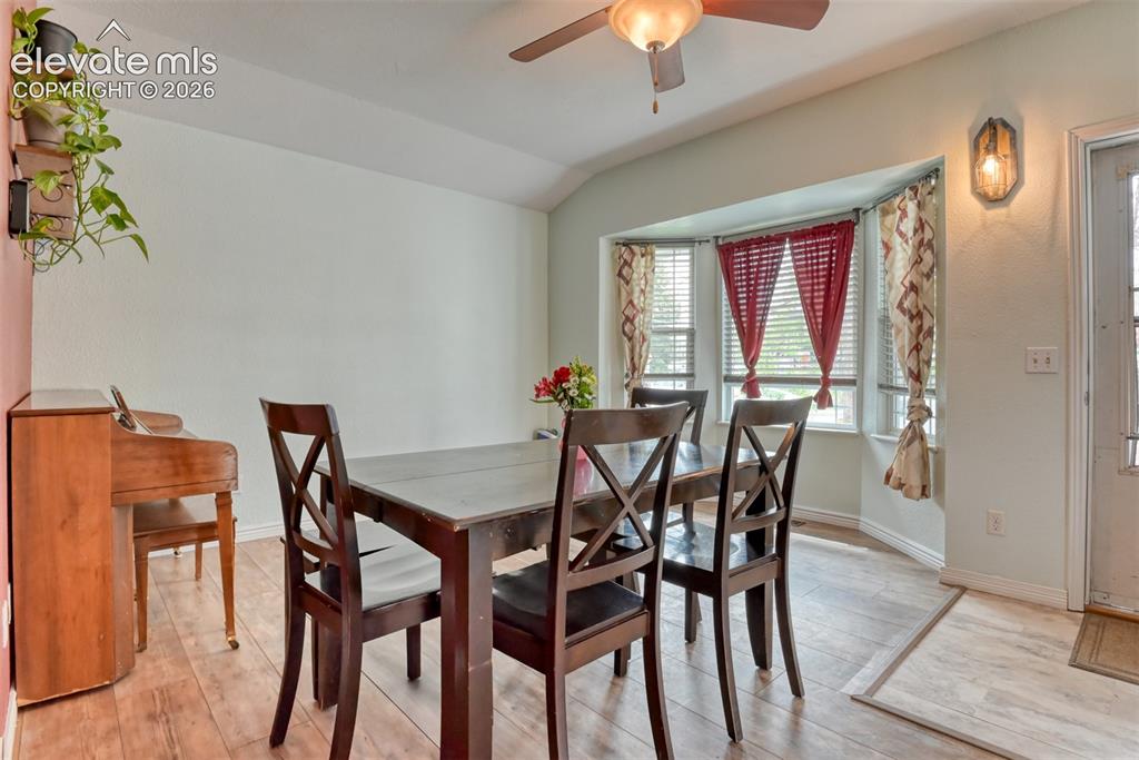Image 11 of 40: Dining area with bay windows, wood-finish flooring, a ceiling fan with inte
