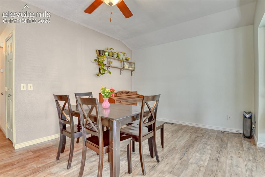 Image 13 of 40: Dining area featuring wood-finish flooring, a ceiling fan with integrated l