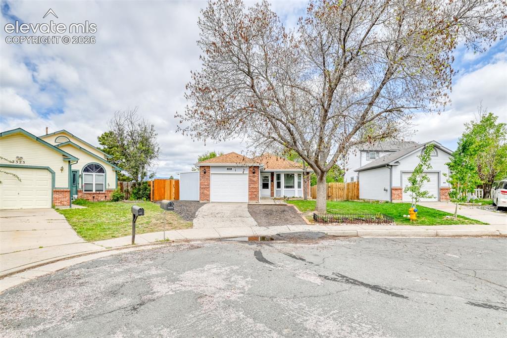 Image 2 of 40: Red brick facade residence with a single-car garage and concrete driveway