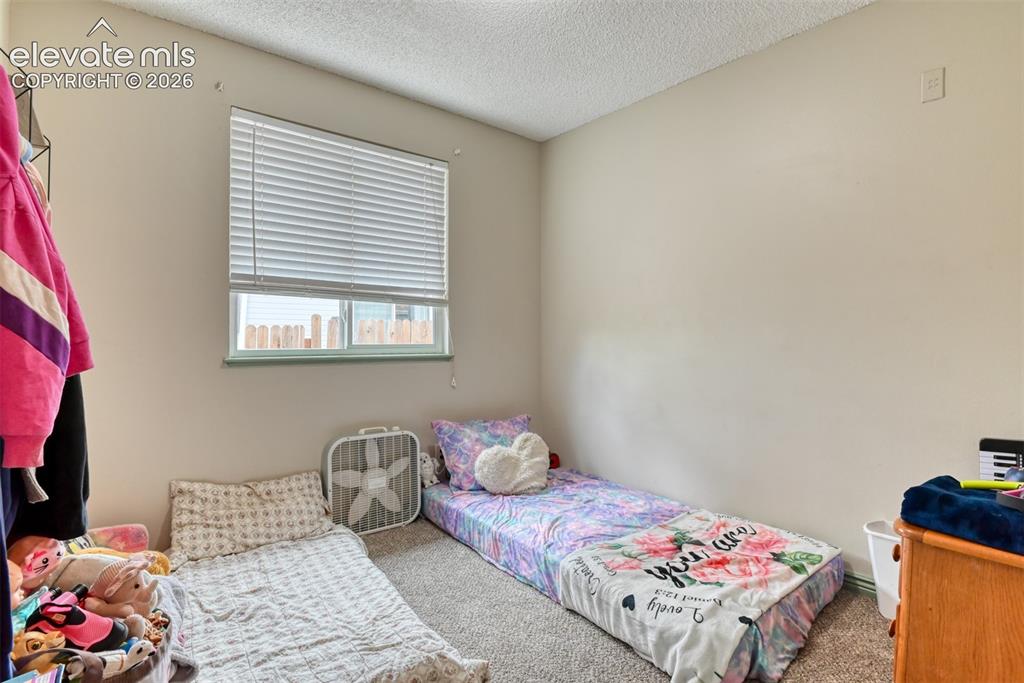 Image 21 of 40: Carpeted room featuring a window with horizontal blinds, light-toned walls,