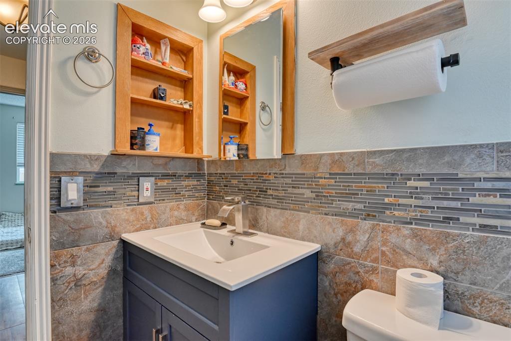 Image 27 of 40: Bathroom vanity featuring a white countertop, undermount sink, and brushed 