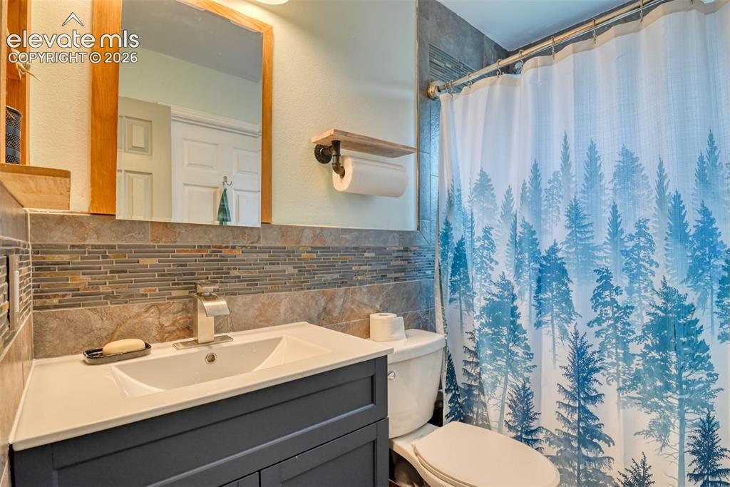 Image 28 of 40: Bathroom vanity with a white countertop and integrated sink, complemented b