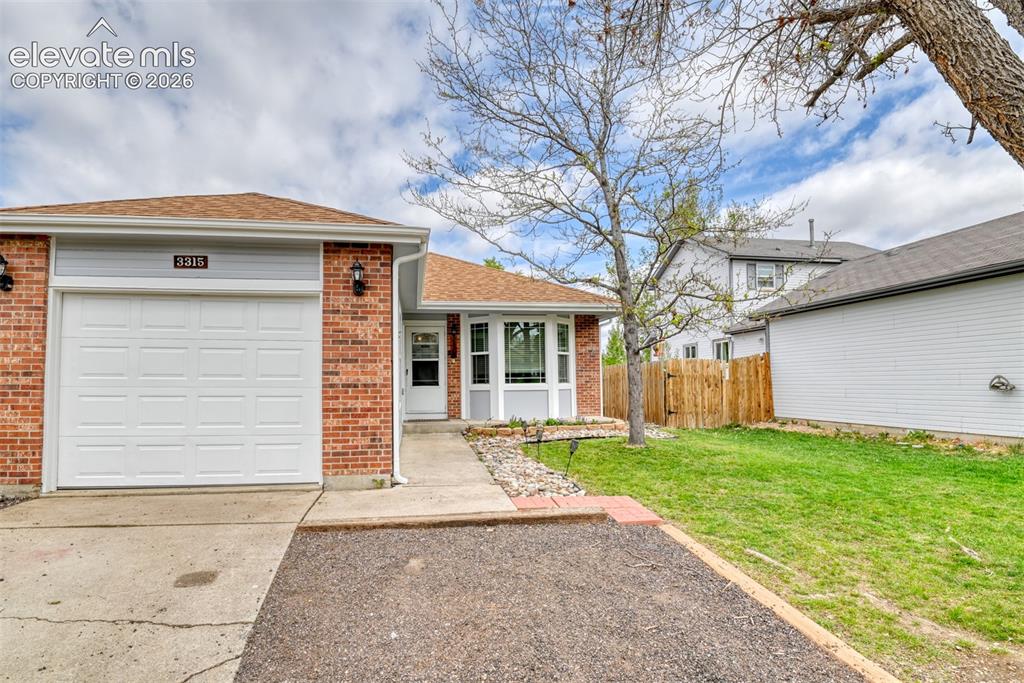 Image 3 of 40: Brick and siding exterior featuring an attached garage with a white panel d