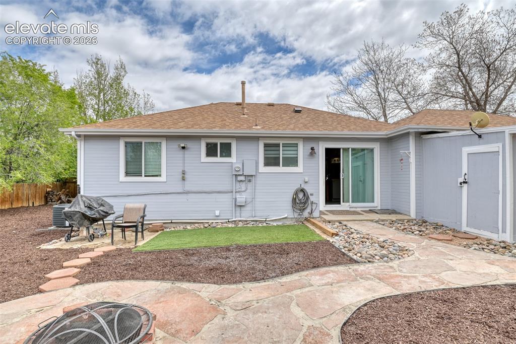 Image 6 of 40: Rear exterior featuring light blue siding, a brown shingle roof, and multip