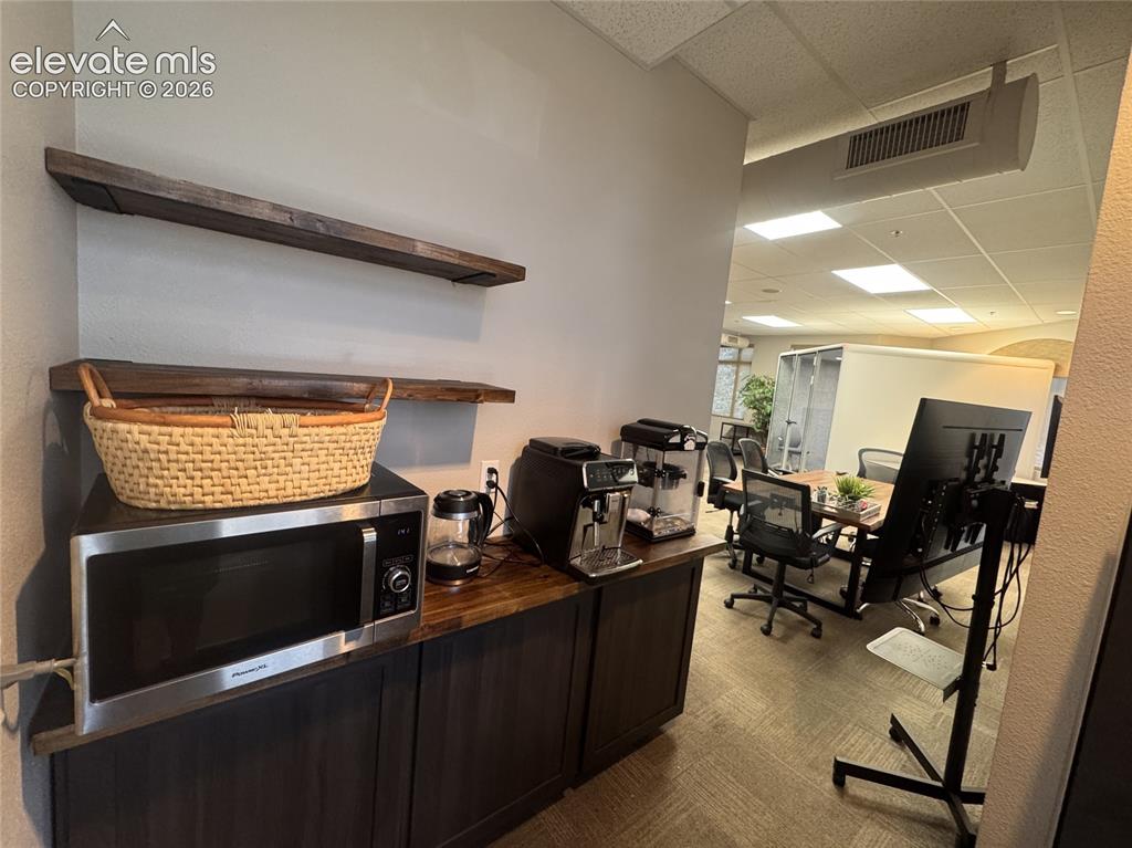 Image 11 of 17: Built-in cabinetry with wood-finish countertop, two wood-finish floating sh