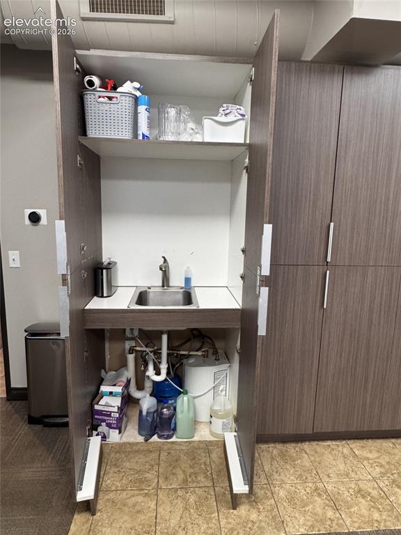Image 13 of 17: Built-in cabinetry with a stainless steel sink and integrated faucet, compl