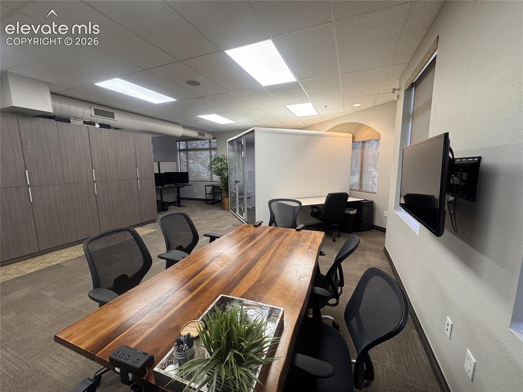 Image 4 of 17: Open-concept office space with wood-finish built-in cabinetry, recessed lig