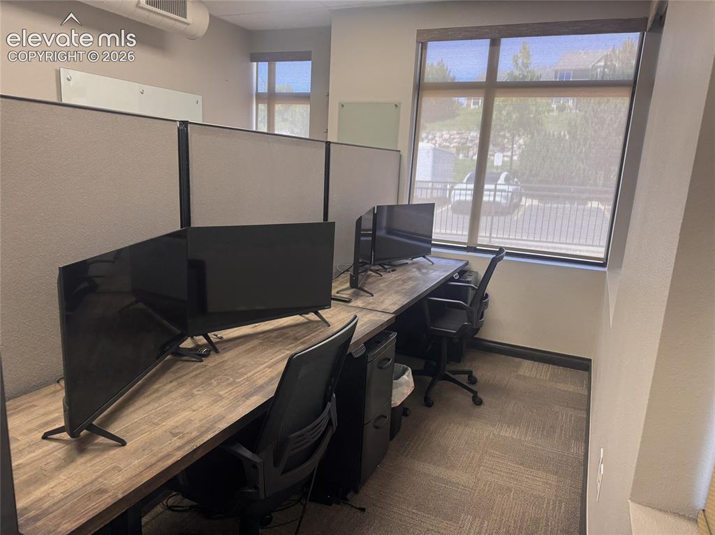 Image 5 of 17: Modular workstation with wood-finish desktops, carpeted flooring, and large