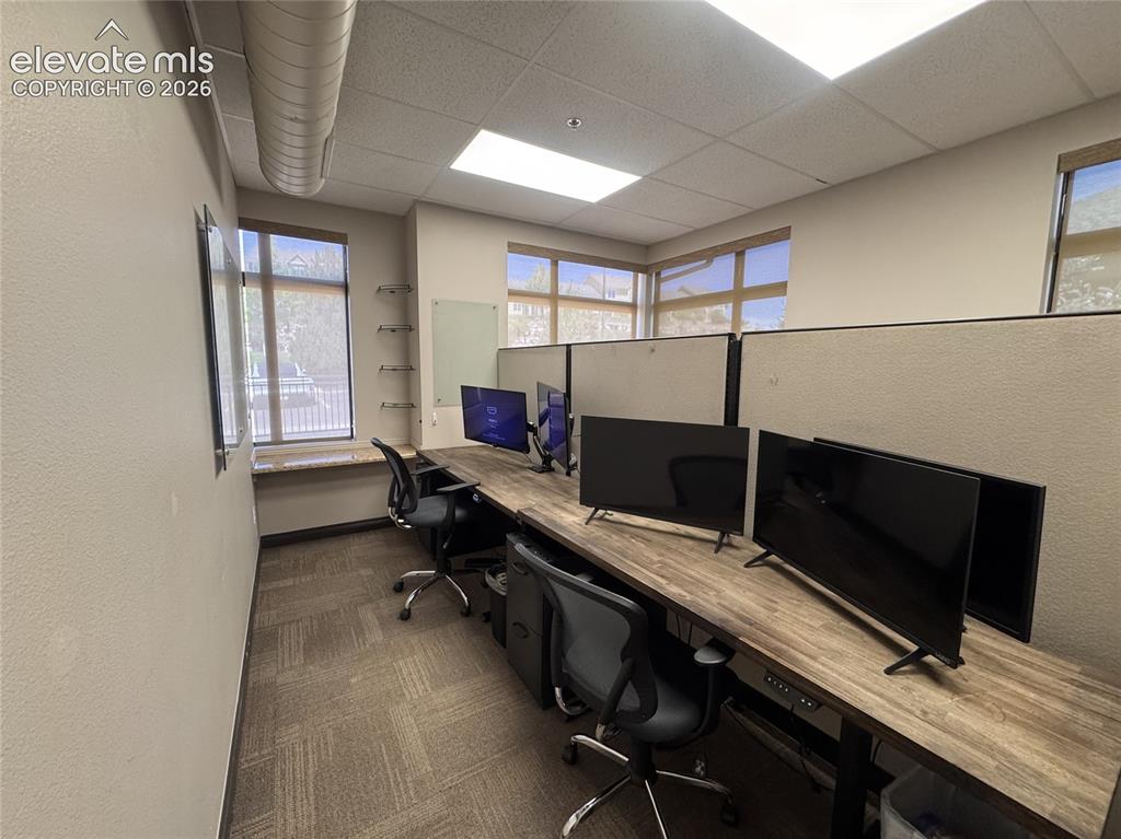 Image 6 of 17: Dedicated office space featuring large windows, wood-finish countertops, mo